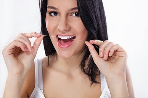 Woman flossing teeth for optimal oral health